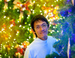happy asian man at home looking at camera and smiling wishing friends and family Merry Christmas and New Year.