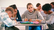 © Monkey Business - Secondary Or High School Students Collaborating In Study Area With Teachers In Background