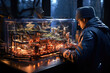 © apratim - Man working on a highly detailed miniature city model with LED lights in a dimly lit room.