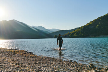 Triathlon athlete starting swimming training on lake