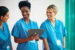 © Monkey Business - Team Of Mature Female Multi Cultural Medical Team In Scrubs With Digital Tablet Meeting In Hospital