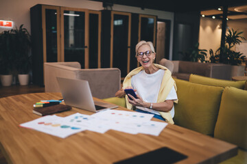 Successful happy business woman administrator enjoying working on laptop computer, while sitting in office