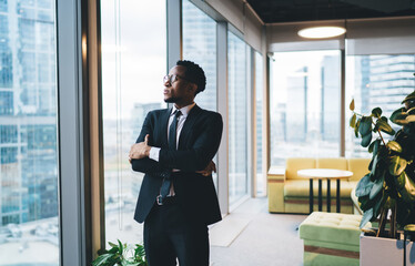 Sticker - Confident black businessman in suit standing near glass wall