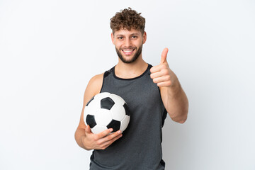 Wall Mural - Young handsome caucasian man isolated on white background with soccer ball and with thumb up