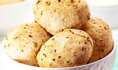 Sticker - bowl full of traditional brazilian cheese bread or cheese biscuit, served crispy and hot, with coffee