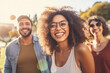 Young beautiful smiling african american woman with glasses in front of her friends having fun outdoors on a sunny day with sunlight.generative ai