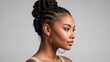© OneMoreTry - A beautiful black african american woman with a perfect clean face and pigtails gathered in a bun. 3/4 side view. Natural beauty. Gray background.