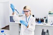 © Krakenimages.com - Young blonde woman scientist pouring liquid on test tube at laboratory