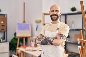 Canvas Print - Young bald man smiling confident standing with arms crossed gesture at art studio