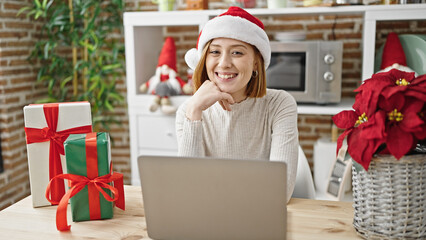 Poster - Young blonde woman using laptop celebrating christmas at dinning room