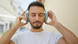 © Krakenimages.com - Young arab man listening to music at street