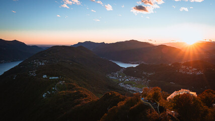 Wall Mural - The sunset and the landscape seen from Mount San Salvatore at the end of an autumn day, near the town of Lugano, Ticino, Switzerland - 31 October 2023.