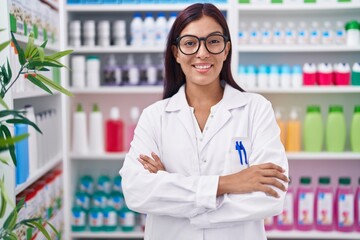 Canvas Print - Young beautiful hispanic woman pharmacist smiling confident standing with arms crossed gesture at pharmacy