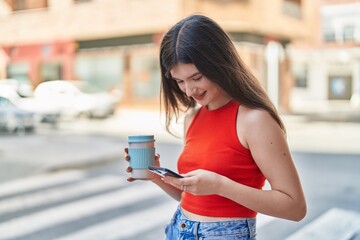 Sticker - Young caucasian woman using smartphone drinking coffee at street