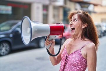 Canvas Print - Middle age woman using megaphone screaming at street