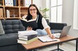 © Krakenimages.com - Young beautiful hispanic woman business worker reading book writing on document at office