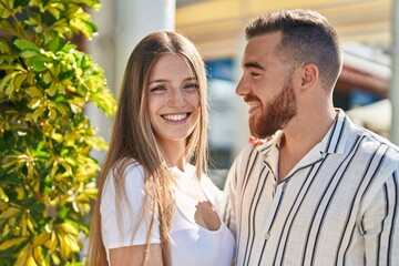 Man and woman couple smiling confident hugging each other at street