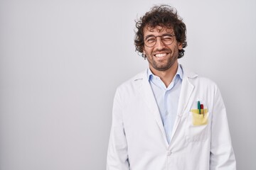 Sticker - Hispanic young man wearing doctor uniform winking looking at the camera with sexy expression, cheerful and happy face.