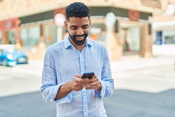 Sticker - Young arab man smiling confident using smartphone at street