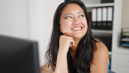 Wall Mural - Young chinese woman business worker using computer looking to the side at the office