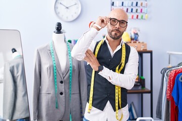 Canvas Print - Young bald man tailor smiling confident standing with arms crossed gesture at tailor shop