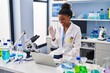 © Krakenimages.com - Young african american with braids working at scientist laboratory with laptop looking positive and happy standing and smiling with a confident smile showing teeth