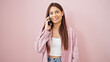 © Krakenimages.com - Young beautiful hispanic woman smiling confident talking on the smartphone over isolated pink background