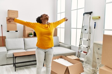 Poster - African american woman smiling confident standing with arms open at new home