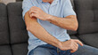 Middle age man scratching arm for itchy at home