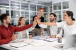 © New Africa - Team of employees joining hands in office