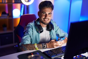 Poster - Young hispanic man streamer using computer and smartphone at gaming room