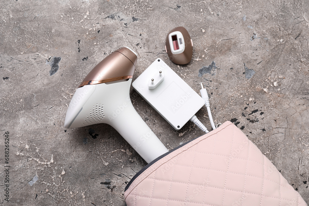 Bag with charger and attachment for modern photoepilator on grunge grey background