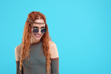 Poster - Stylish young hippie woman in sunglasses on light blue background, space for text