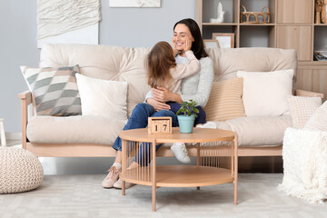 Canvas Print - Beautiful mother with her cute little daughter sitting on sofa at home