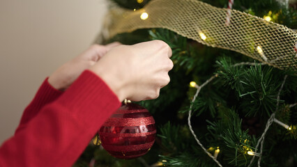 Poster - Young blonde woman decorating christmas tree at home