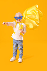 Poster - Little girl after chemotherapy dressed as superhero with ribbons on yellow background. Childhood cancer awareness concept