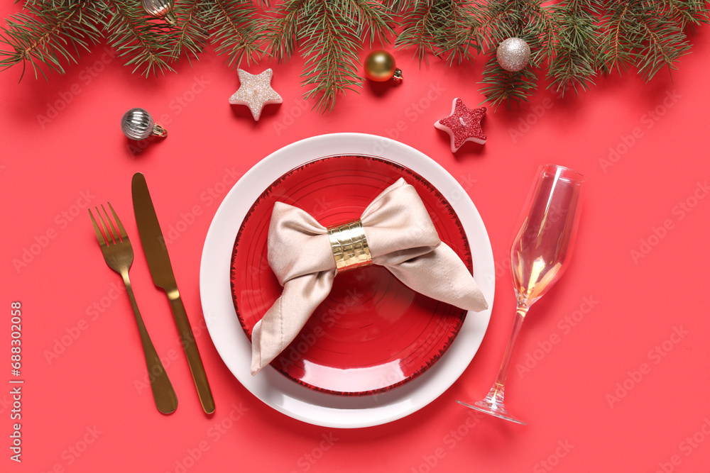 Beautiful table setting with fir branches, Christmas balls and candles on red background