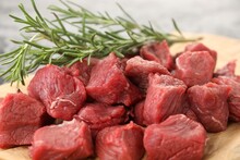 Pieces Of Raw Beef Meat And Rosemary On Parchment, Closeup
