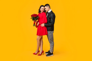 Sticker - Loving young couple with bouquet of beautiful roses on yellow background. Celebration of Saint Valentine's Day