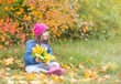 © Ermolaev Alexandr - Happy young girl with Downs syndrom sits on autumn leaves. Empty space for text