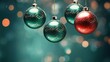  three christmas baubles hanging from a string on a blue and green background with blurry lights in the background.