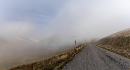 Poster - mountain road leading into thick fog in the Gran Sasso and Monti della Laga National Park