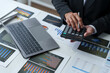 © Phimwilai - Asian businesswoman works on laptop and calculates with financial calculator from graphs, statistics, charts. Planning. Business success results in modern office.
