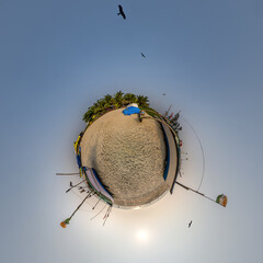 Wall Mural - coconut trees in jungle in Indian tropic village on sea shore with fisher boat on little planet in evening sky, transformation of spherical 360 panorama.