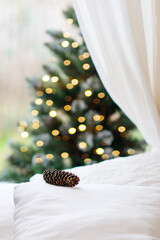 Wall Mural - christmas home interior. element white room with a bed with a white sheet, on it lies a pine cone. c