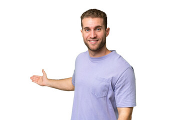 Wall Mural - Young handsome caucasian man isolated on green chroma background extending hands to the side for inviting to come