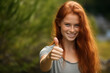 © luismolinero - Young pretty redhead woman at outdoors with thumb up