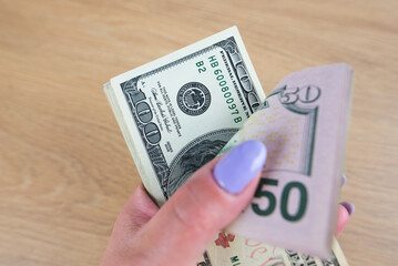 Wall Mural - Dollars in a woman's hand close-up. Much money.