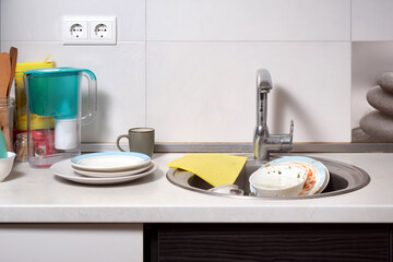 Kitchen sink with dirty dishes after dinner in a home interior.