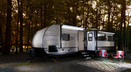 Wall Mural - Camping trailer all set up for the campers to start their glamping adventure in the thick forest they are parked in.